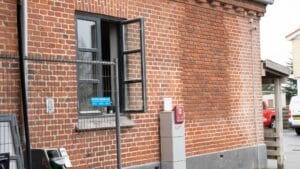 Murstensbygning med åbent vindue og luftstation